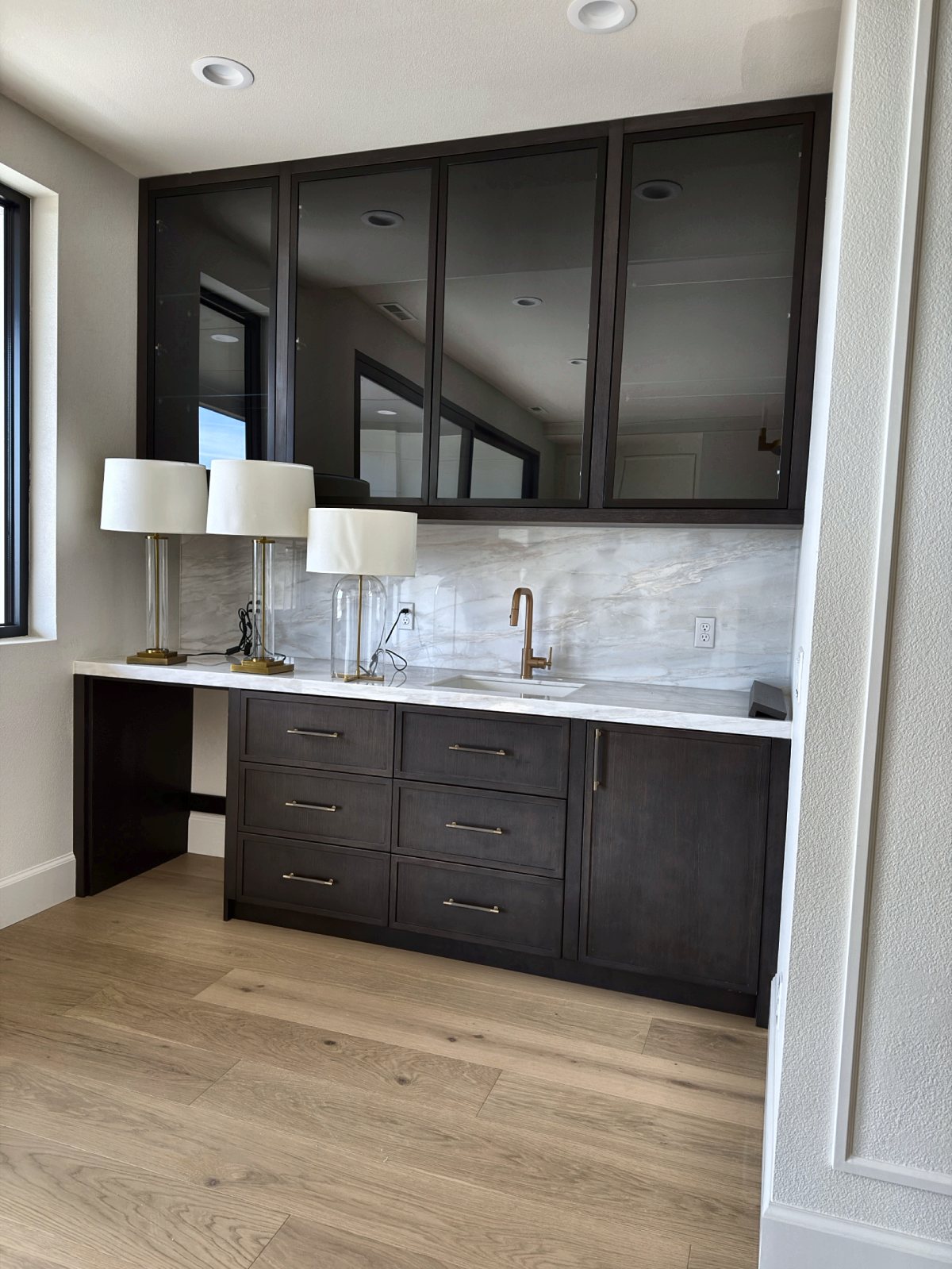Dark walnut wet bar with smoked glass uppers