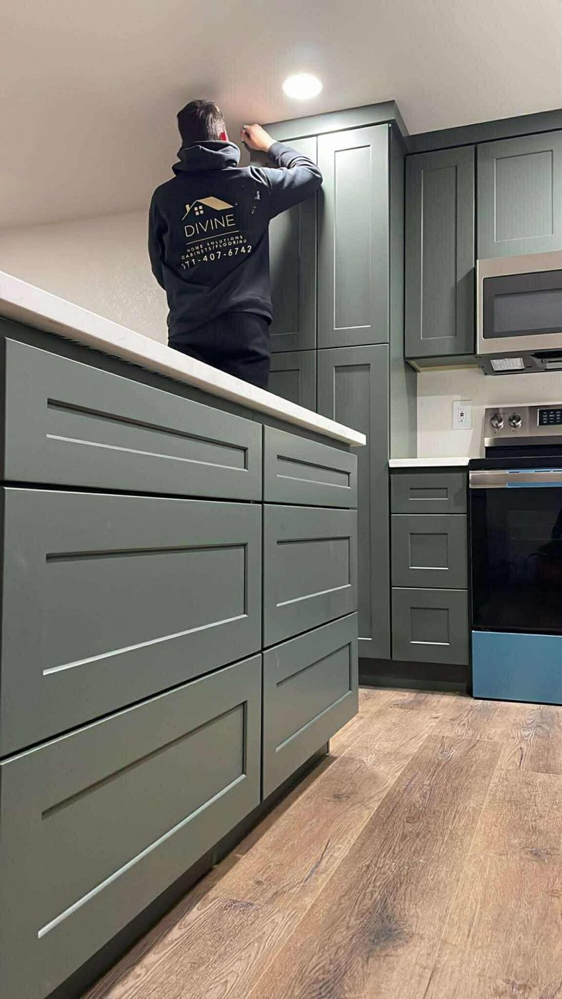 Divine Home Solutions installer fitting sage green shaker cabinets